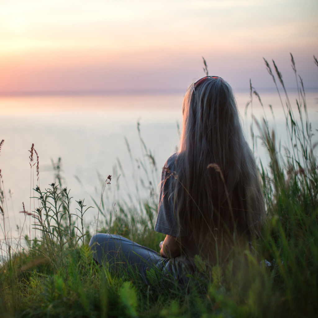 Woman sitting, looking serene and peaceful.