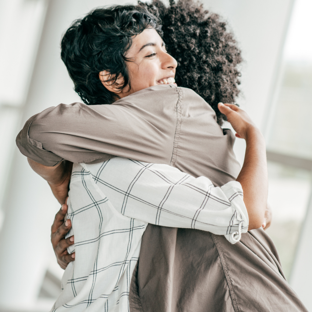 Two women hugging and supporting each other