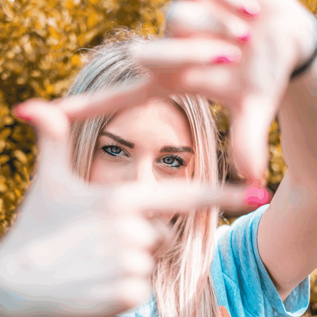 Woman holding a camera pose with her fingers