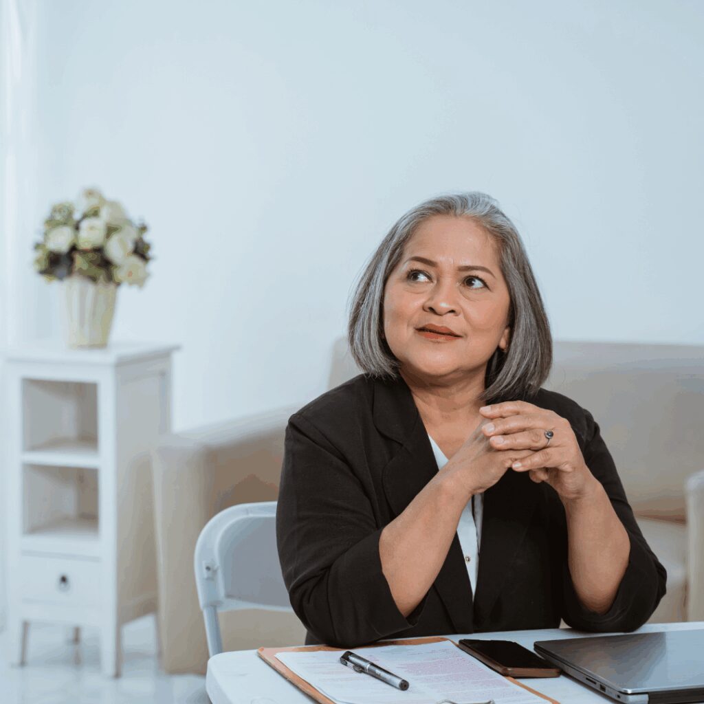 Business woman at desk looking thoughtful