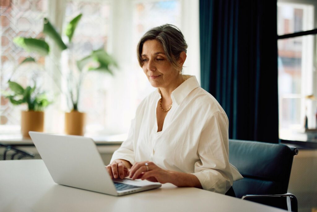 Lady in white shirt sitting at desk and typing on laptop.

Unsplash: search woman presenting in meeting office